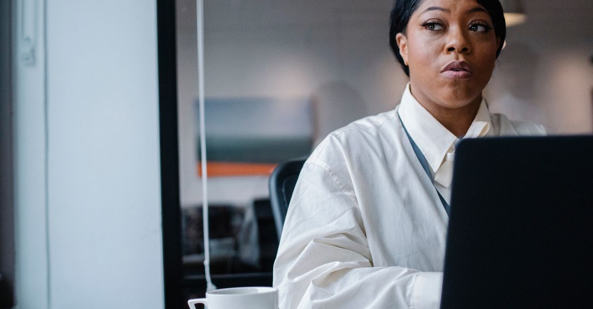 An African businesswoman working on a laptop in an office.